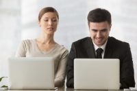 Interested curious corporate spy looking at colleagues laptop, spying on rival, cheating on examination, stealing idea, sneaking peek, taking inquisitive glance at computer screen of unaware coworker