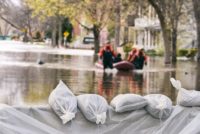 Flood Protection Sandbags with flooded homes and businesses in the background
